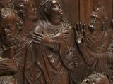 carvings of a group of people standing around a statue of a man