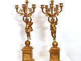 deux bougeoirs dorés ornés d'anges