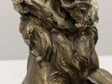 a bronze statue of a lion with a long mane