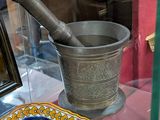 une vitrine en verre sur laquelle sont posés un bol et un pinceau à mortier