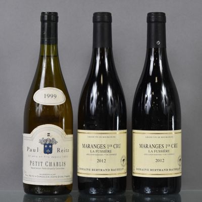 three bottles of wine are lined up on a glass table