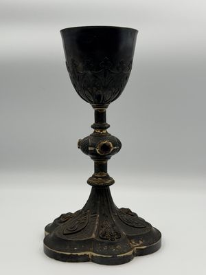 an antique black and gold goblet sitting on top of a white table