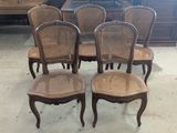 four chairs with wicker back and cane back are in a room