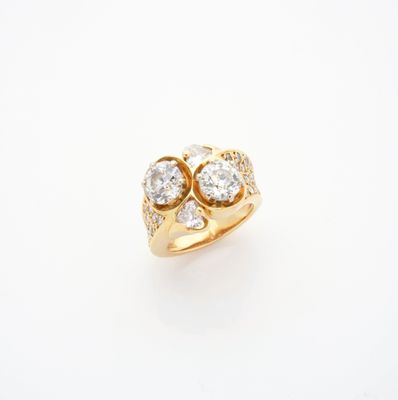 une bague en or sertie de trois diamants sur fond blanc