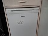 a small white dishwasher in the corner of a kitchen
