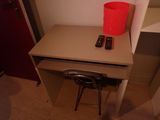 a small desk with two remote controls on top of it