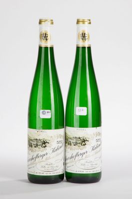 two bottles of wine sitting next to each other on a white surface