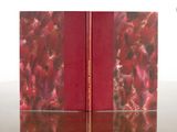 two red books sitting on top of a table next to each other