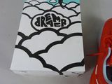 a box with a pair of red shoes next to a pair of orange shoes