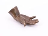 a statue of a hand holding a cup on a white surface