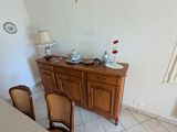 a table and chairs in a room with a clock on the wall