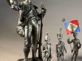 statue of a man holding a flag and standing next to other figurines