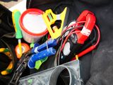 a black bag filled with assorted tools on the ground