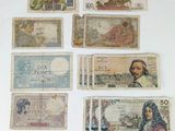 several different types of paper money are displayed on a white surface