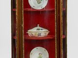 une armoire rouge sur laquelle sont posées des assiettes