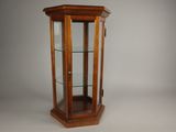une vieille vitrine en bois avec des étagères en verre et une porte