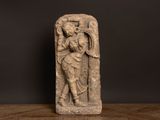 a stone statue of a man holding a sword on top of a wooden table