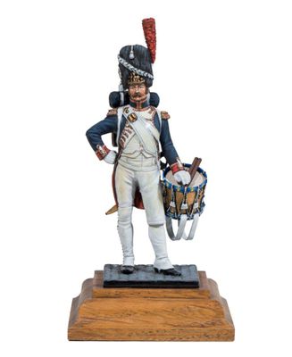 the figurine of a soldier with a drum stands on a wooden base