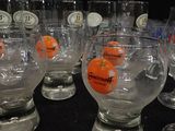 many glasses with oranges in them sitting on a table