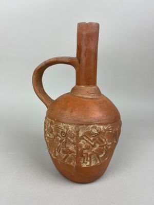 a brown vase that has a handle on it