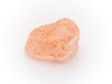 a small piece of orange colored rock on a white surface
