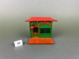 a close up of a small green building with a red roof