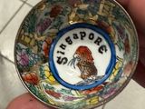 someone is holding a small bowl with a picture of a bird on it