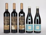 cinq bouteilles de vin sont alignées sur une surface blanche