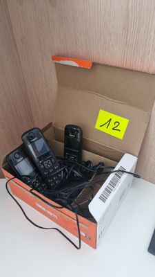 une boîte de téléphones portables posée sur un bureau, à côté d'un clavier