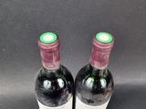 two bottles of wine are sitting on a table with a black background