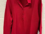 a red sweater hanging on a white wall