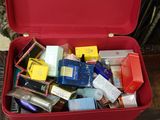 a red suitcase filled with assorted items on a table