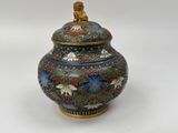 a large vase with a lid on a white surface