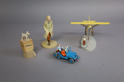 plusieurs figurines représentant des personnages et un avion, posées sur une surface grise