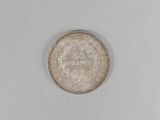 a close up of a silver coin on a white surface