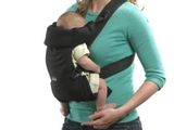 une femme tenant un bébé dans un porte-bébé