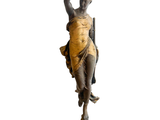 statue d'une femme tenant une épée, posée sur un socle en bois