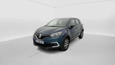Une voiture bleue est garée dans une pièce blanche.