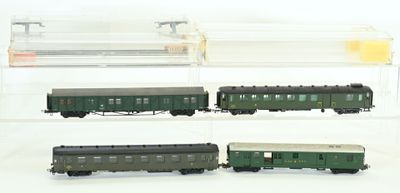 quatre modèles réduits de trains exposés dans une vitrine transparente