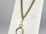 a necklace with a gold chain and a white stone pendant