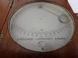 a close up of a clock on a wooden table