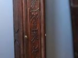 a tall wooden grandfather clock in the corner of a room