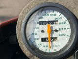 un gros plan sur le compteur de vitesse situé sur le tableau de bord d'une moto