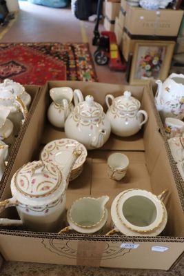 a box full of teapots and cups on a table