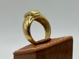 a close up of a gold ring on a wooden block