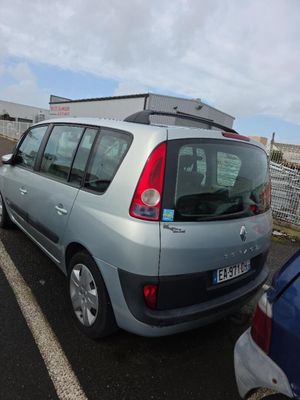 voitures garées sur un parking, avec un bâtiment en arrière-plan