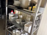 a metal shelf with dishes on it in a kitchen