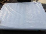 un matelas posé sur une palette au milieu d'un parking