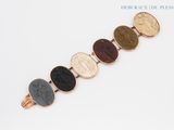 a close up of a bracelet with a coin on it