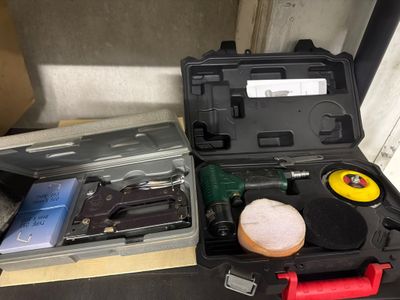 une trousse à outils posée sur une table à côté d'une boîte à outils